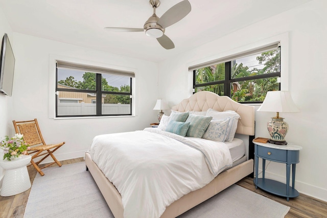 bedroom with multiple windows, ceiling fan, and light hardwood / wood-style flooring