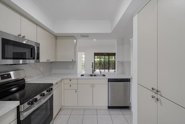 kitchen featuring sink, tasteful backsplash, appliances with stainless steel finishes, light tile patterned flooring, and ornamental molding