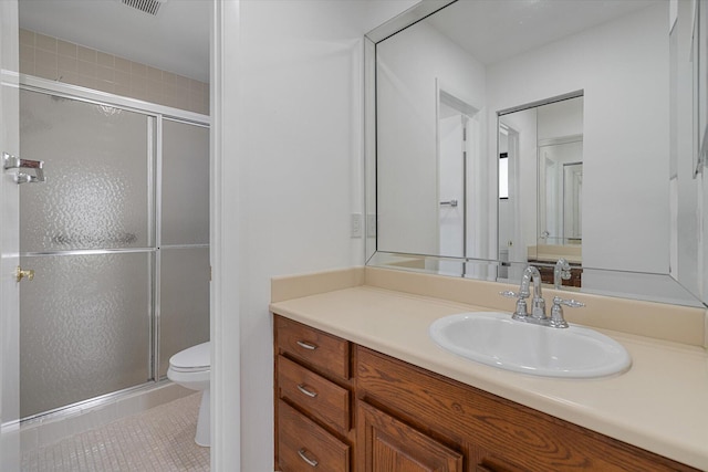 bathroom featuring tile patterned flooring, vanity, an enclosed shower, and toilet