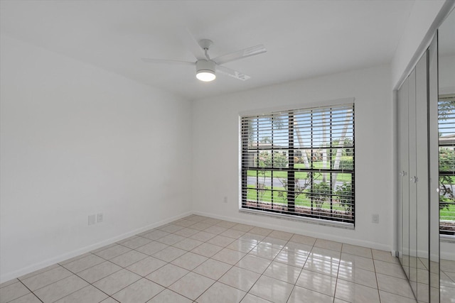 spare room featuring ceiling fan and light tile patterned flooring