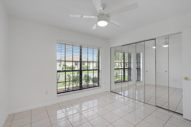 tiled spare room featuring ceiling fan