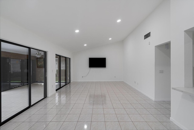 spare room featuring light tile patterned floors, vaulted ceiling, and ceiling fan