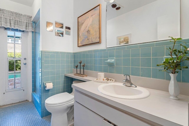 full bathroom with shower / tub combo with curtain, toilet, tile walls, vanity, and tile patterned flooring