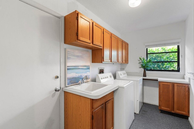 laundry room featuring separate washer and dryer, sink, cabinets, dark carpet, and a textured ceiling