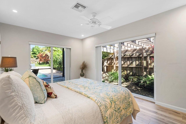 bedroom featuring ceiling fan, access to exterior, multiple windows, and light hardwood / wood-style flooring