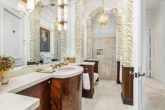 bathroom with crown molding, toilet, vanity, and an inviting chandelier