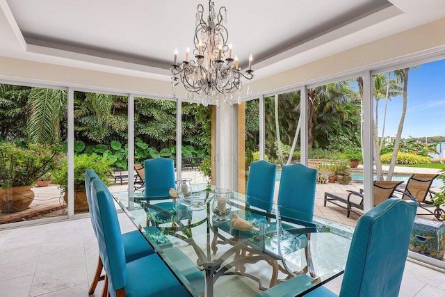 sunroom / solarium featuring a raised ceiling and a notable chandelier