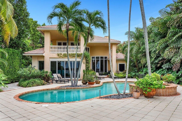 rear view of property with a patio area and a balcony