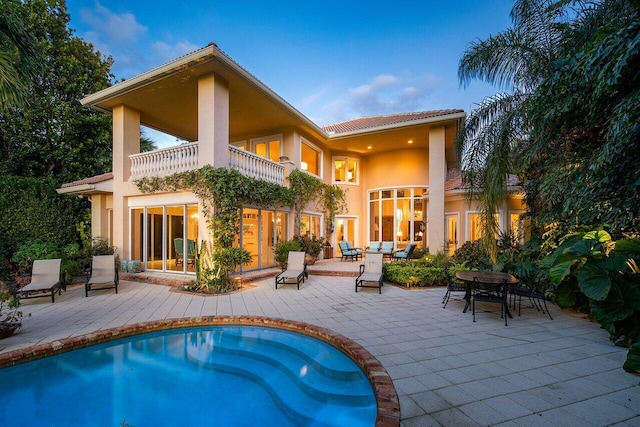 rear view of house featuring a balcony and a patio