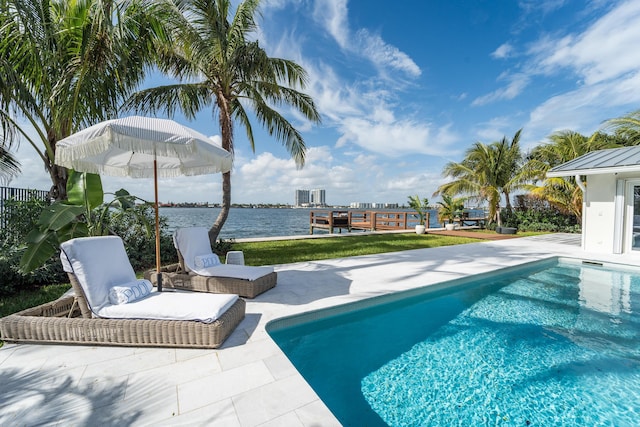 view of swimming pool with a patio and a water view