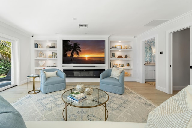 living room featuring built in shelves, sink, ornamental molding, and light hardwood / wood-style floors