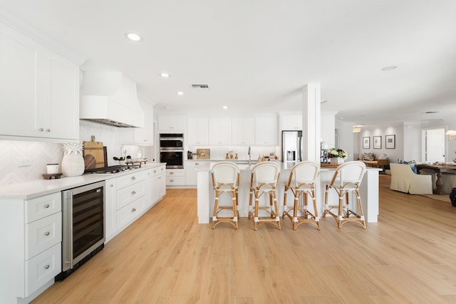 kitchen featuring beverage cooler and white cabinets