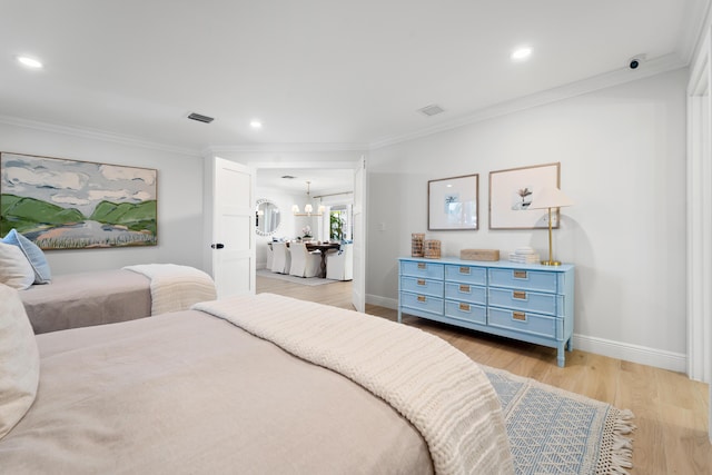 bedroom with light wood-type flooring, an inviting chandelier, and crown molding