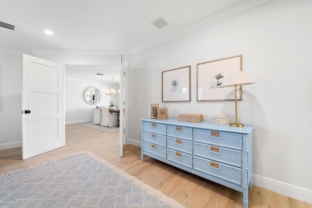 interior space featuring ornamental molding, hardwood / wood-style floors, and a notable chandelier