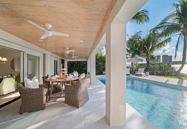 view of swimming pool featuring ceiling fan and a patio