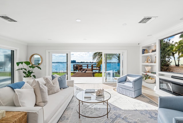 living room featuring crown molding, built in features, and light hardwood / wood-style flooring