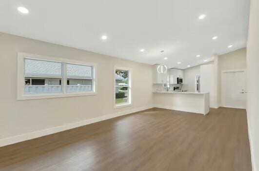 unfurnished living room featuring dark wood-type flooring