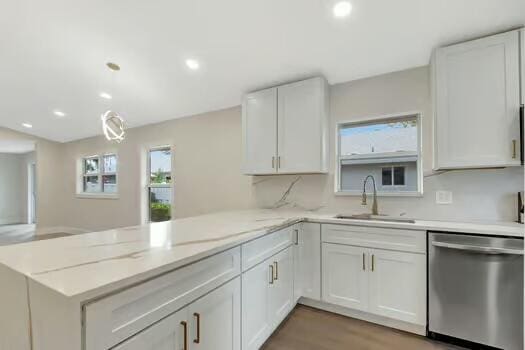 kitchen featuring kitchen peninsula, sink, and stainless steel dishwasher