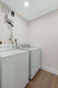 laundry area with washer and clothes dryer and light hardwood / wood-style flooring