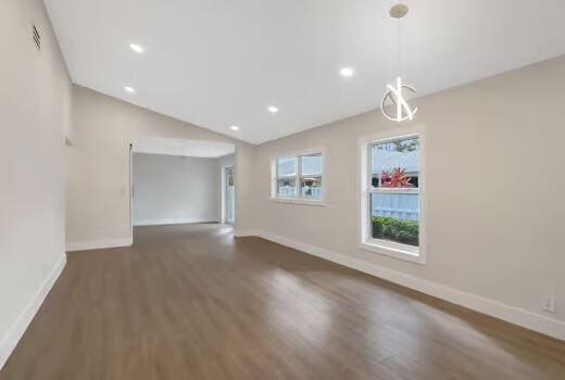 unfurnished living room featuring dark hardwood / wood-style flooring and lofted ceiling