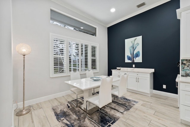 dining room featuring crown molding and light wood-type flooring