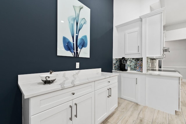 bathroom featuring vanity, wood-type flooring, and tasteful backsplash