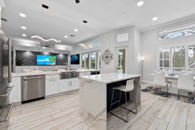 kitchen featuring sink, white cabinets, pendant lighting, and appliances with stainless steel finishes