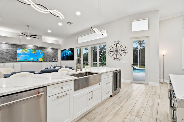 kitchen with ceiling fan, sink, stainless steel dishwasher, pendant lighting, and white cabinets