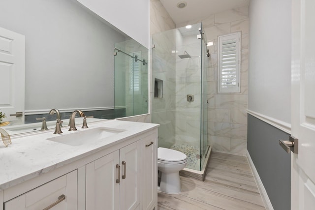 bathroom featuring hardwood / wood-style floors, toilet, and a shower with shower door