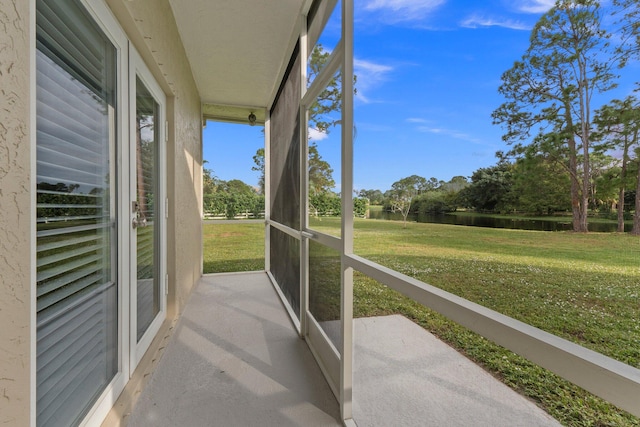 unfurnished sunroom featuring a water view