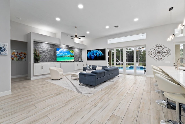 living room with light hardwood / wood-style floors, plenty of natural light, and ceiling fan