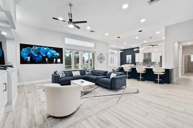 living room with light hardwood / wood-style flooring and ceiling fan