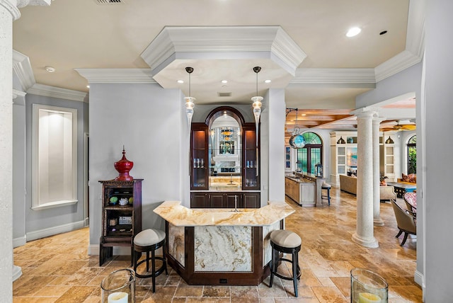 bar with hanging light fixtures, ornamental molding, decorative columns, and ceiling fan