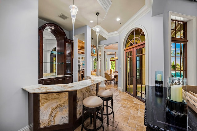 bar with pendant lighting, ornamental molding, a healthy amount of sunlight, and ornate columns