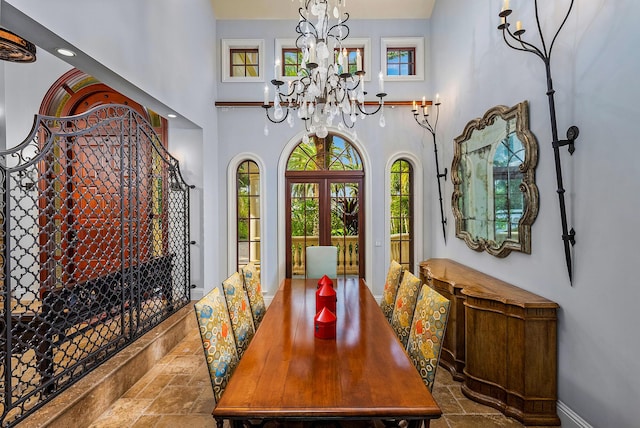 dining area featuring a high ceiling, a notable chandelier, and french doors