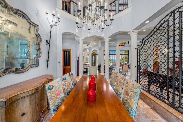 dining space featuring a towering ceiling and ornate columns