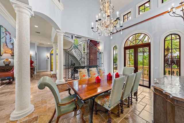 dining room with decorative columns, ornamental molding, a healthy amount of sunlight, and a high ceiling