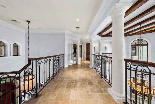 hall with beamed ceiling, ornamental molding, and decorative columns