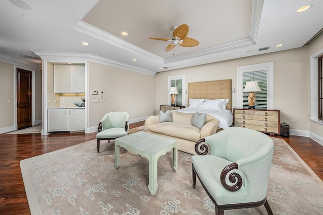 bedroom with ornamental molding, wood-type flooring, and a tray ceiling