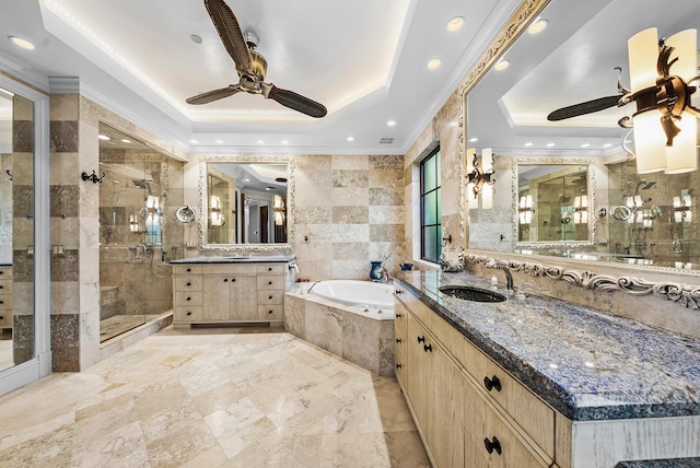 bathroom with crown molding, tile walls, vanity, a tray ceiling, and separate shower and tub