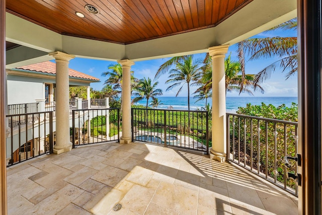 view of patio with a balcony and a water view