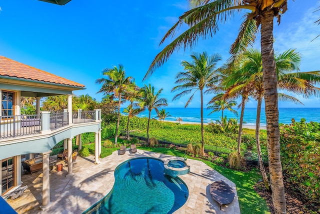 view of pool featuring a patio area, an in ground hot tub, and a water view