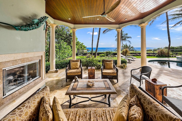 view of patio featuring a water view, ceiling fan, and a fenced in pool