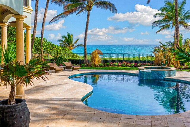 view of swimming pool featuring an in ground hot tub, a patio, and a water view