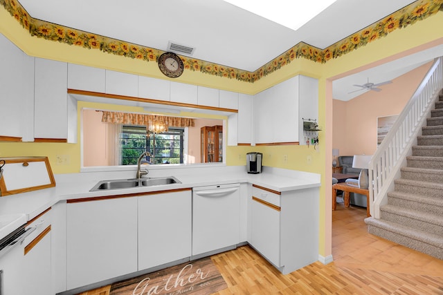 kitchen with dishwasher, ceiling fan with notable chandelier, sink, light hardwood / wood-style flooring, and white cabinetry