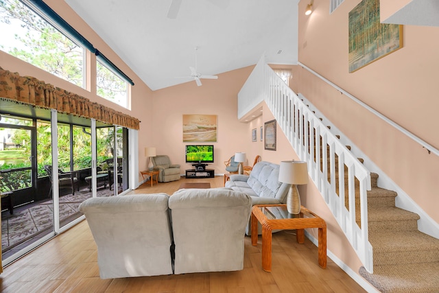 living room featuring ceiling fan, light hardwood / wood-style floors, and high vaulted ceiling