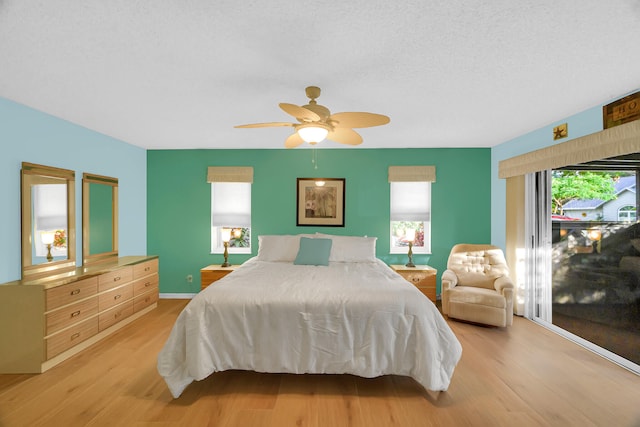 bedroom featuring ceiling fan, light hardwood / wood-style floors, and a textured ceiling