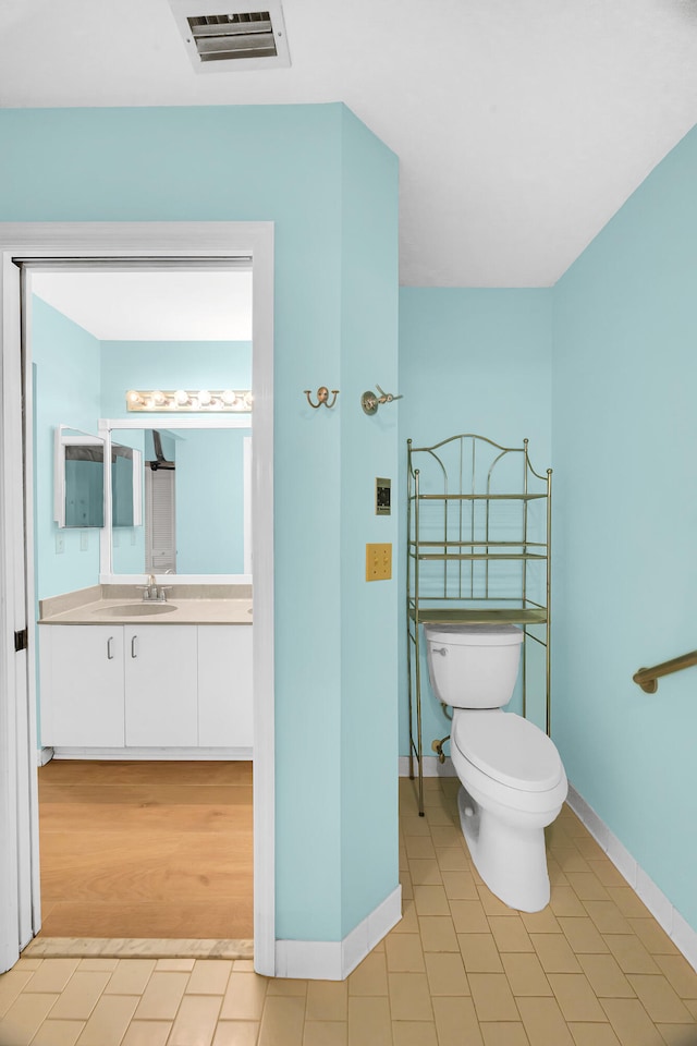 bathroom featuring hardwood / wood-style flooring, vanity, and toilet