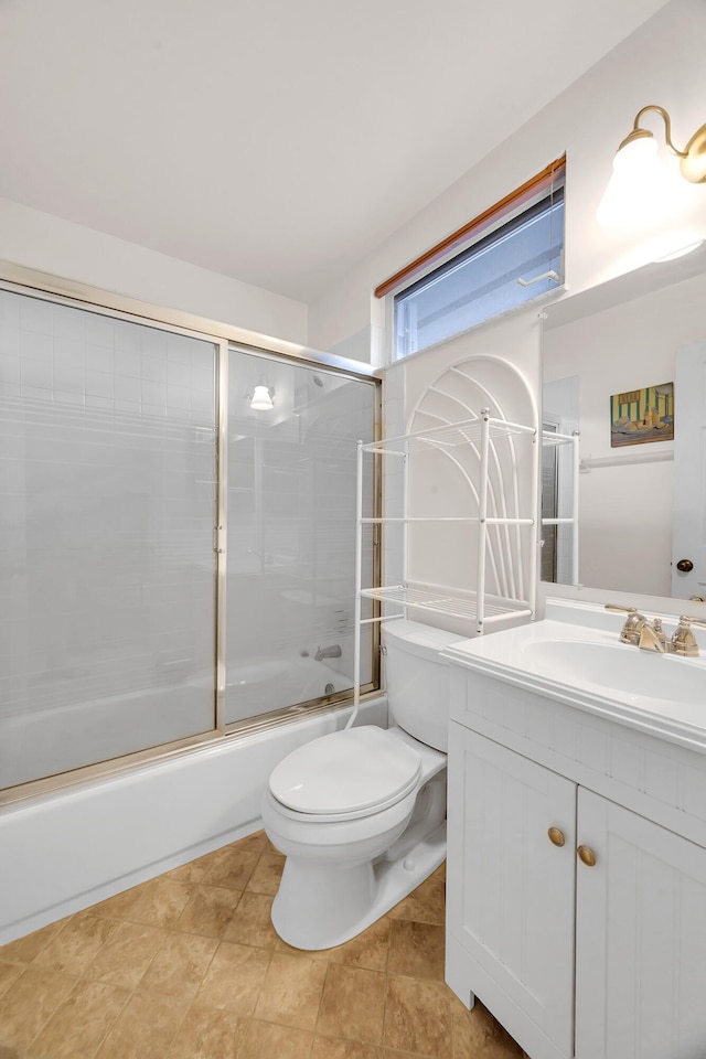 full bathroom featuring tile patterned flooring, vanity, toilet, and bath / shower combo with glass door