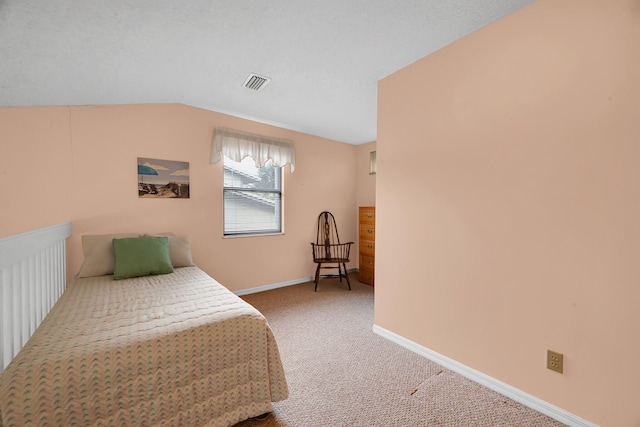 carpeted bedroom with a textured ceiling and vaulted ceiling